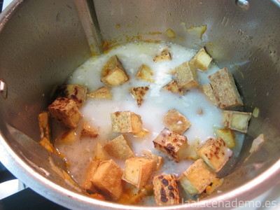 Paso 7: añade las patatas, el tofu, las especias y la leche de coco